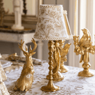 Gold Toile Christmas table styled with gold resting reindeer, Gold Toile lamp shade and gold hammered lamp base